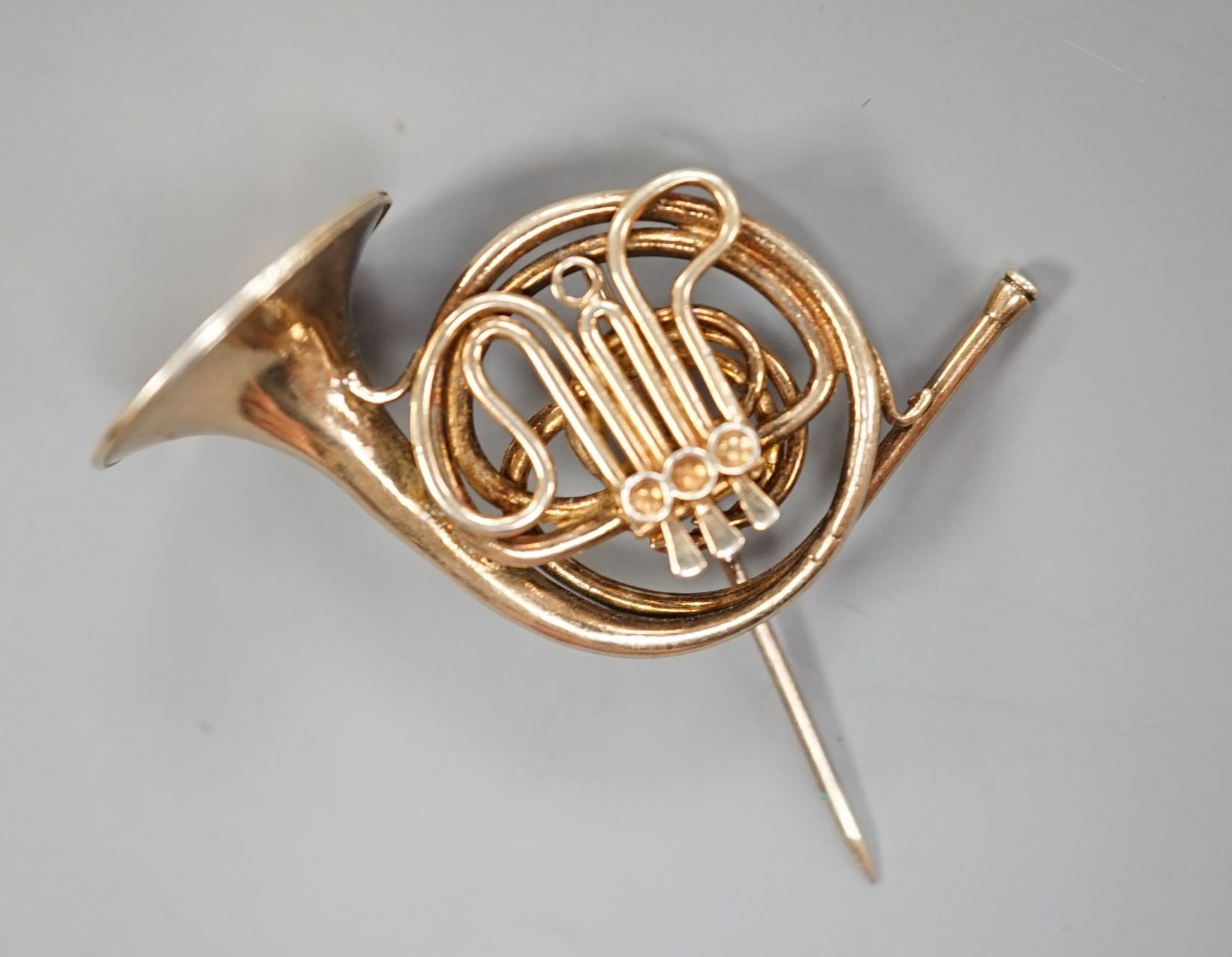 A modern silver gilt brooch, modelled as a French horn, maker, JC, London, 1981, 30mm.